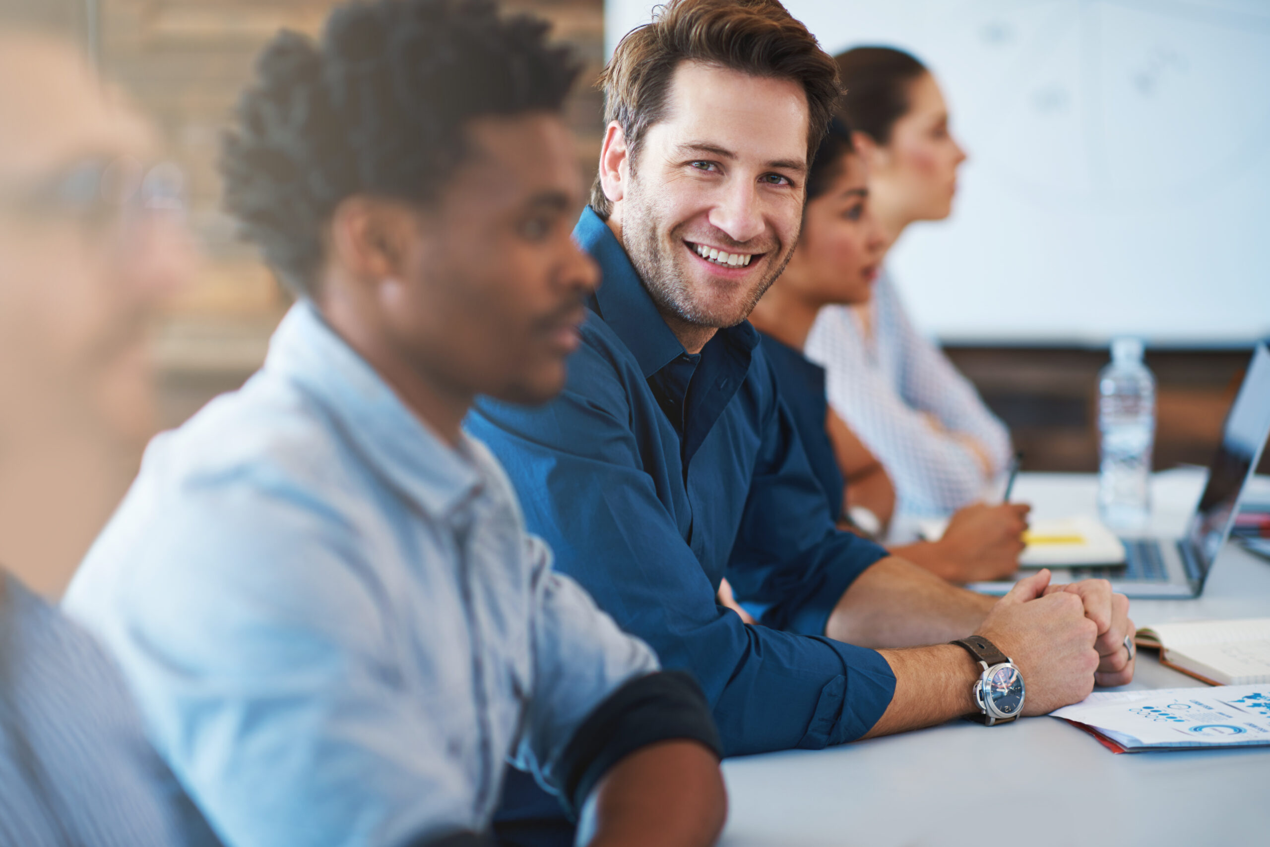 Portrait, happy and a business man in the boardroom with his team during a meeting for planning. Smile, strategy or collaboration with a male employee and colleagues in the office for a seminar