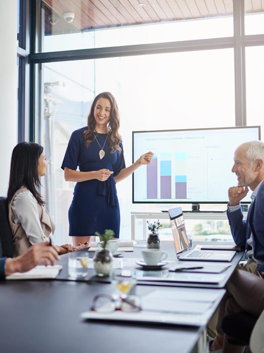 Businesswoman analysis giving a statistic presentation in a diverse boardroom